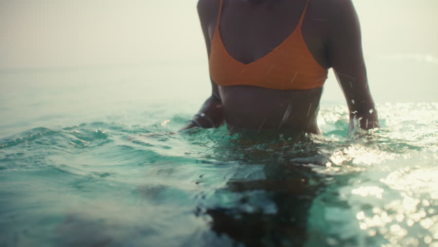 Joyful family vacation moments as a mother and her child swim and play in the warm ocean at a luxury tropical resort.