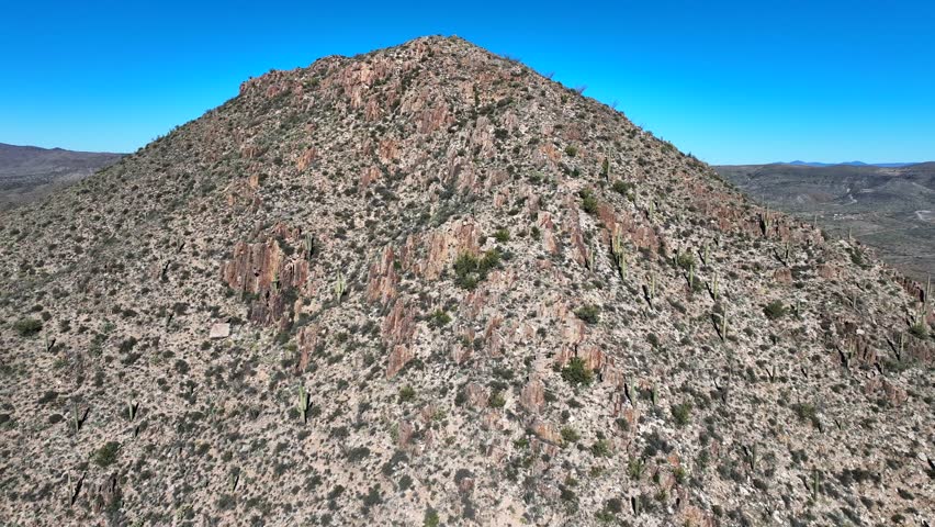 Aerial view of arid mountains with sparse vegetation, contrasting with the clear blue sky above, Agua Fria National Monument, Arizona, United States.