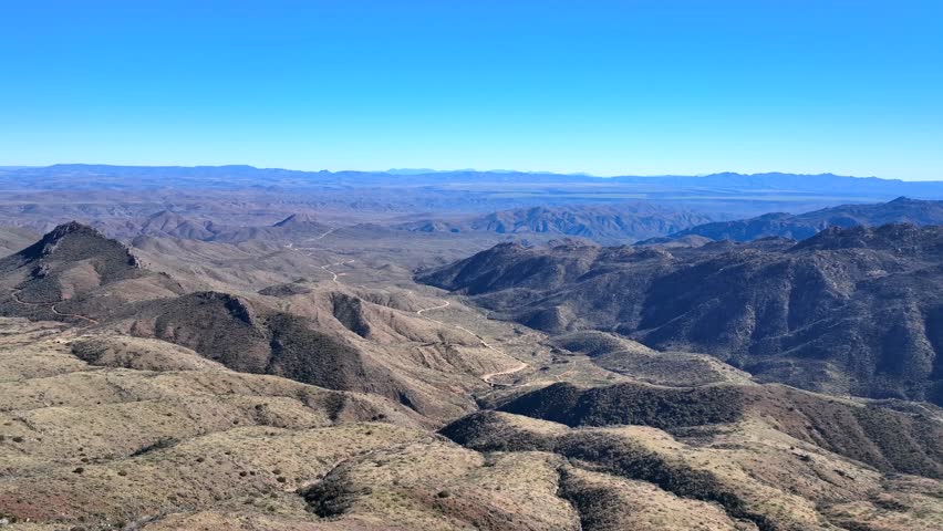 Aerial view of rugged Agua Fria National Monument, showcasing the arid beauty of winding trails and contrasting sunlit and shadowed slopes, Black Canyon City, Arizona, United States.