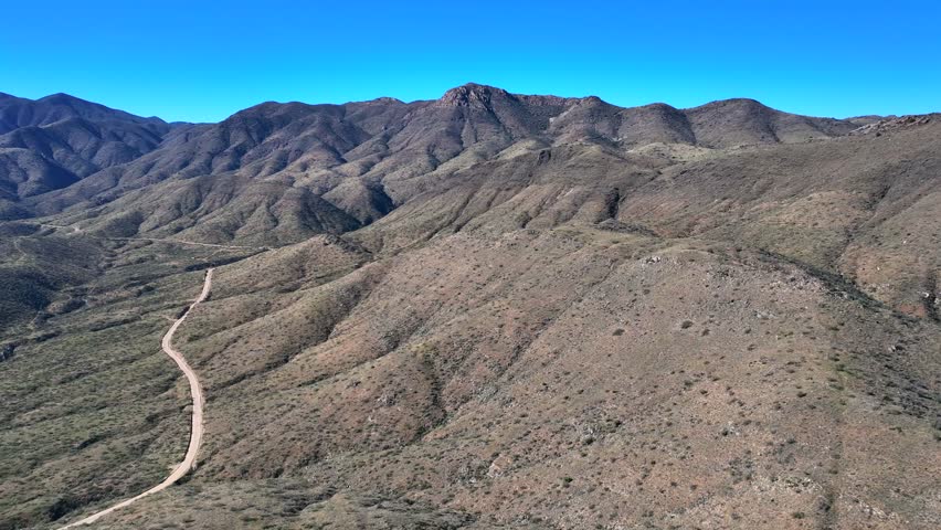 Aerial view of Agua Fria National Monument's rugged terrain, with its undulating hills and winding roads under a clear sky, Black Canyon City, Arizona, United States.
