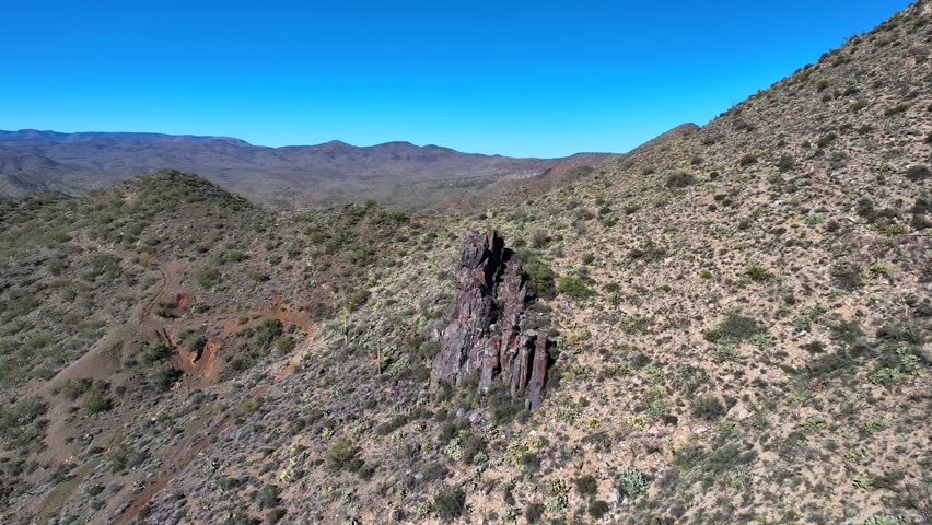 Aerial view of rugged mountains dotted with cacti, showcasing the arid landscape under a clear blue sky, Agua Fria, Arizona, United States.