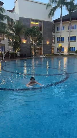 An Asian boy enjoying his vacation by swimming on the swimming pool