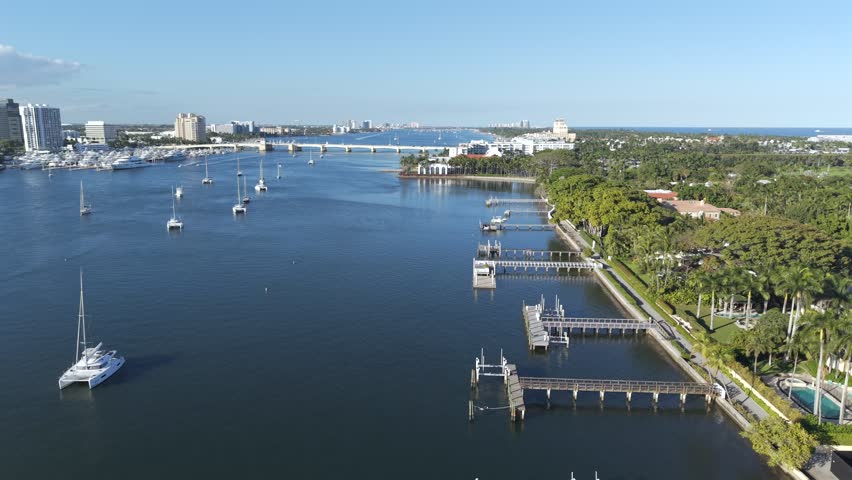 Aerial view of boats on the water, bridge in the background, contrasting with the green trees, West Palm Beach, Florida, United States.