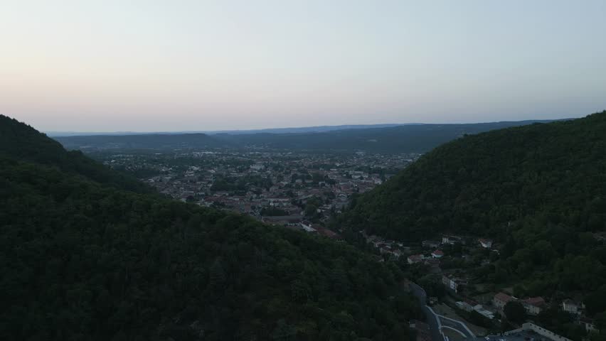 Breathtaking drone footage capturing the historic town of Mazamet nestled within the lush valleys of Southern France during the serene golden hour