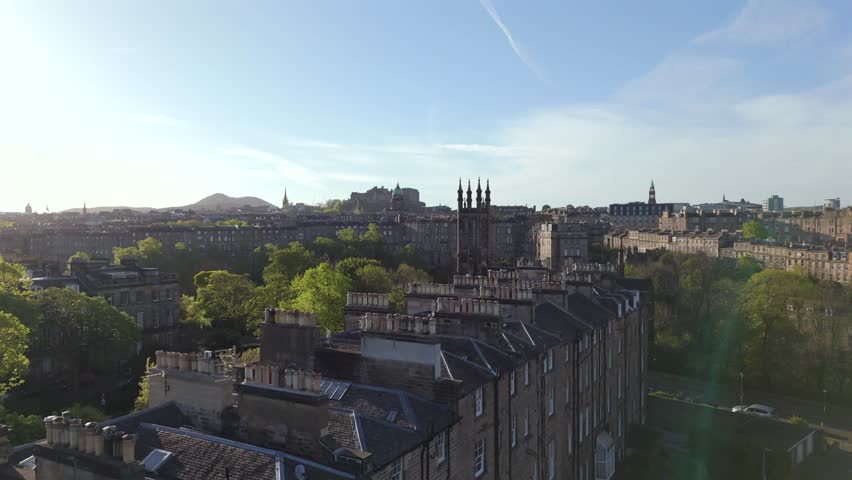 Aerial view of gothic spires rise dramatically against the soft morning light, casting shadows over the ancient stone facades, Edinburgh, United Kingdom.