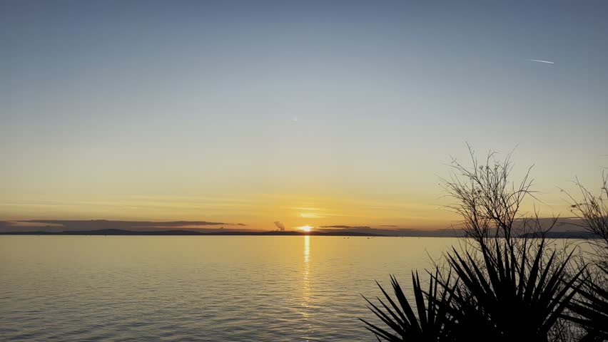 Golden Sunset Over the Adriatic Sea with Calm Water and Coastal Vegetation in Split Croatia