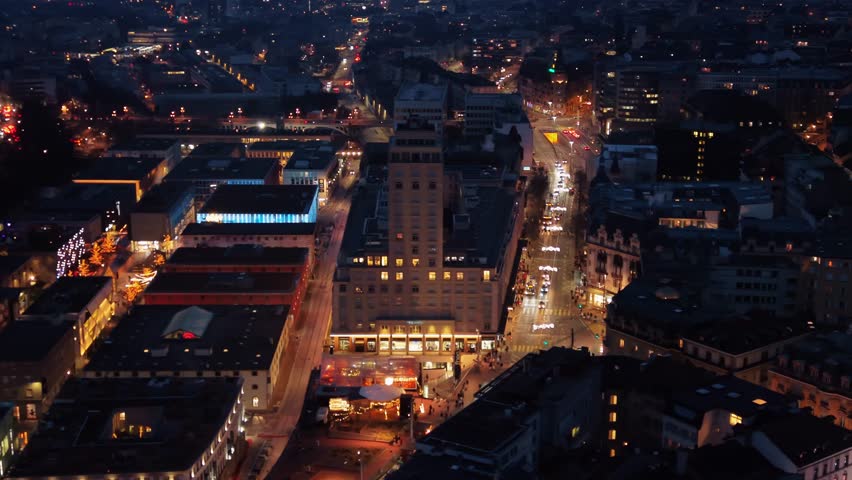 Aerial view of the illuminated Place Bel-Air, a vibrant urban landscape with glowing streets and buildings creating a mesmerizing contrast against the dark sky, Lausanne, Vaud, Switzerland.
