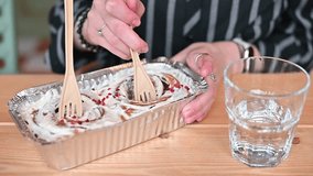 Hands hold spoons and dig into a dessert container filled with creamy layers. A glass of water sits nearby, enhancing the casual dining experience with friends. - Powered by Shutterstock - Get 15% off with code: PIKWIZARD15
