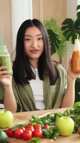 A young Asian woman records a video about healthy ingredients like fruits, vegetables, and olive oil with her smartphone