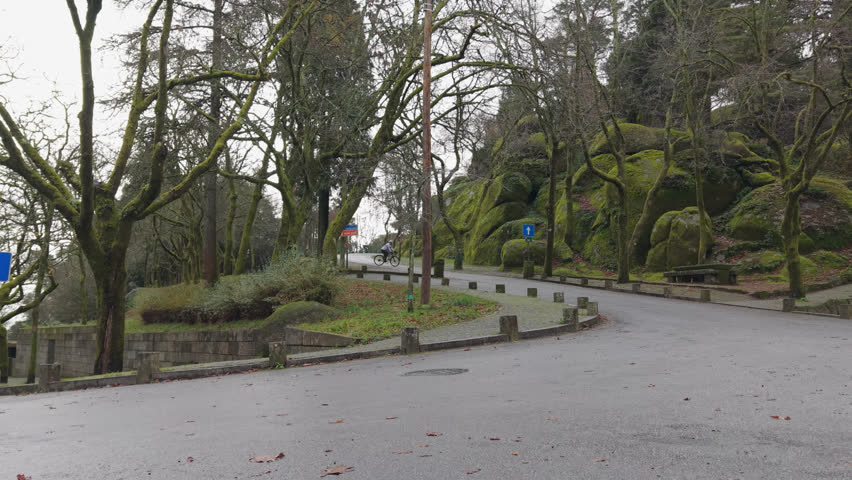 aerial crane up - cyclist riding a bicycle along a curved city street