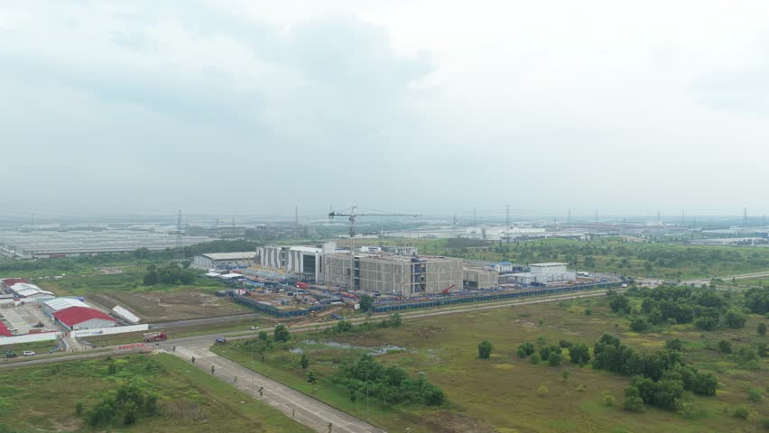 Construction of a digital data center in Jakarta featuring cooling towers and IT systems.