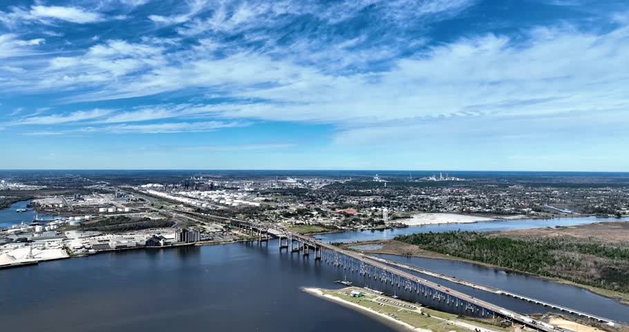 Drone view of a busy bridge in Lake Charles, Louisiana with refineries in the distance
