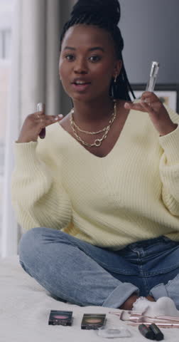 Content creator, talking and black woman with makeup in home for application, how to and tutorial. Influencer, bedroom and person with cosmetics for product review, beauty tips and social media