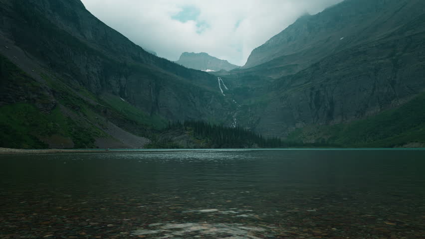 Peaceful lake view with mountains under cloudy skies in Montana