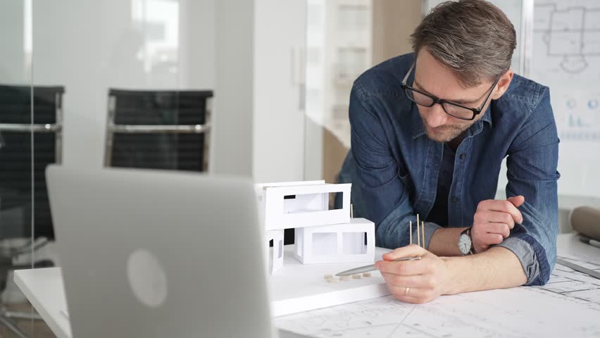 Architect creating building plans and innovative housing design with detailed blueprints. Developing contemporary residential projects