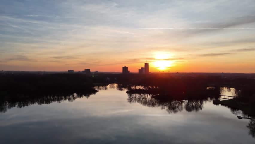Drone Flight Over Lake Toward City Skyline at Sunset