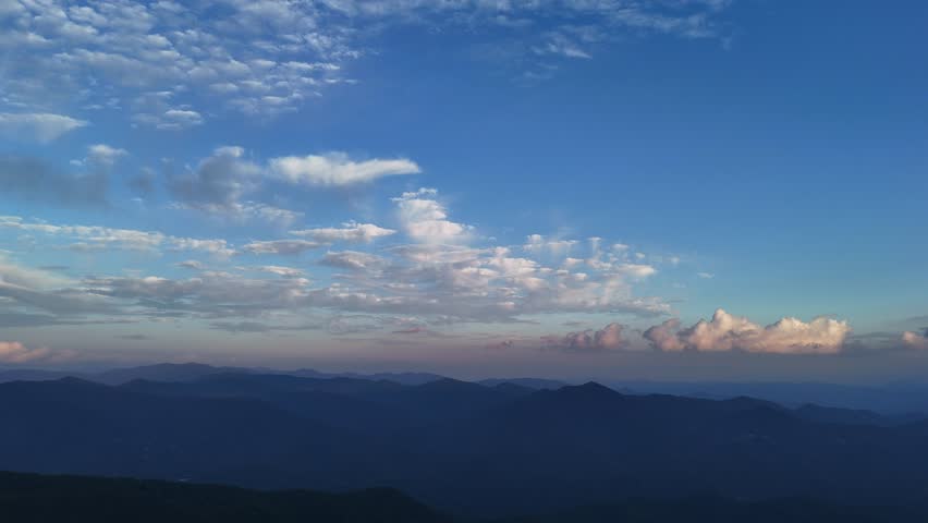 Beautiful clouds moving over mountain landscape at sunset