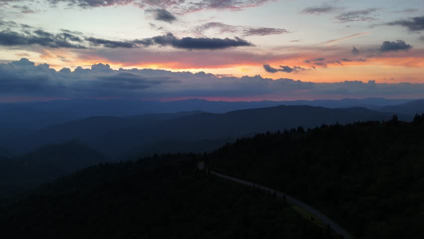 Mountain road driving at sunset aerial view