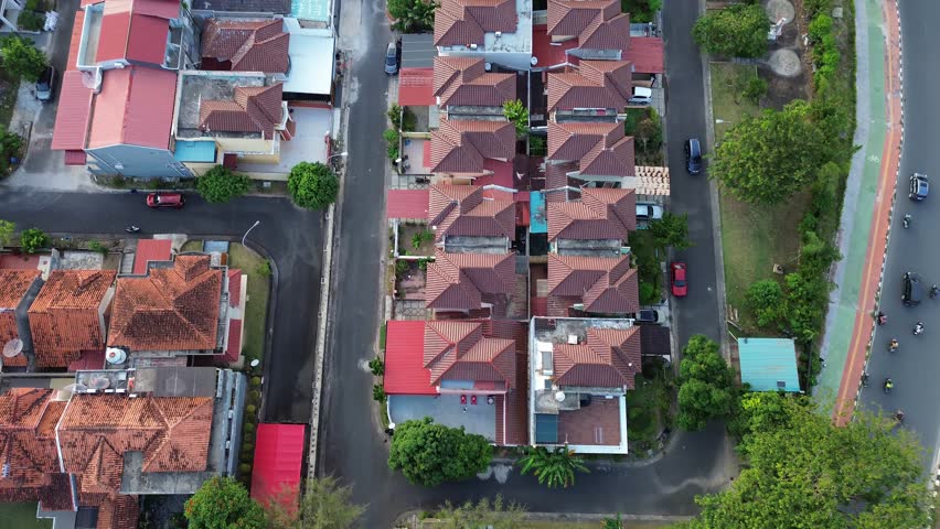 A sweeping aerial view showing a bustling suburban neighborhood with terra-cotta roofs