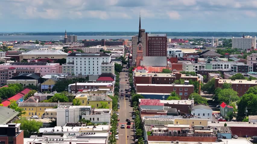 Aerial view of stunning church steeple landscapes of coastal Charleston, South Carolina downtown skyline showcasing lowcountry metropolitan neighborhood scenery - 4K Drone