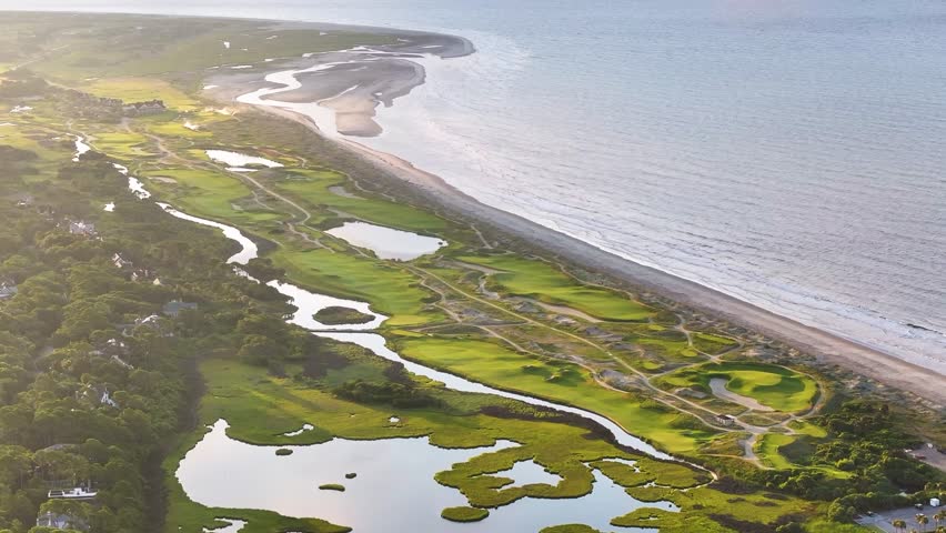 Panoramic Aerial view of ocean golf course on Kiawah Island, South Carolina lowcountry landscapes with beachfront coastal views during morning sunrise - 4K Drone