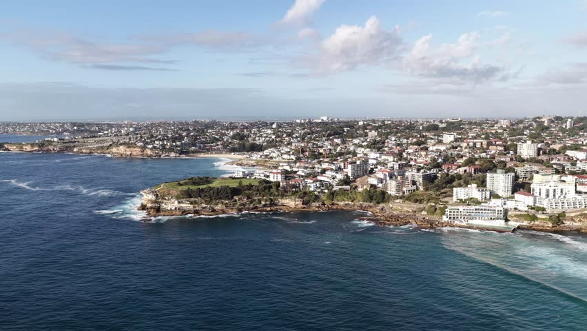 Hovering over Bondi bay beach on Sydney city Eastern Suburbs waterfront – aerial.