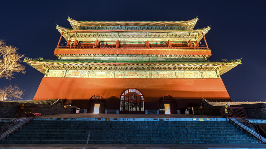 Night scene of tourists at the Drum Tower in Beijing, China, showcasing traditional Chinese-style ancient architecture illuminated at night