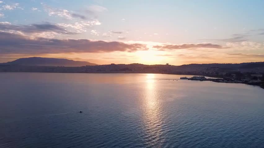 The sun sets over the sea, casting a golden glow on the water, capturing serene ocean scenery, tranquil evening atmosphere, and natural beauty.