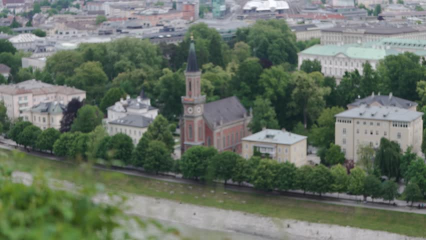 Beautiful view of Christuskirche church with red brick architecture by Salzach river, Salzburg, Austria.