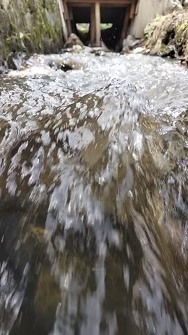 Top view of splashing white water in a fast-flowing mountain stream. High-speed water texture for nature backgrounds, environment, and energy themes
