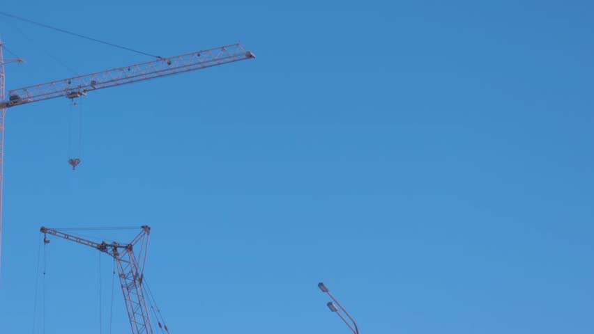 Construction crane stands tall against a clear blue sky during daytime hours