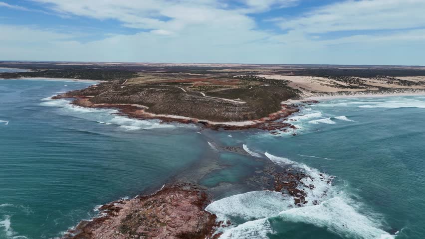 Aerial establishing of rugged headland and swirling ocean waves at Salmon Hole near Daly Head, dolly with whitewash water