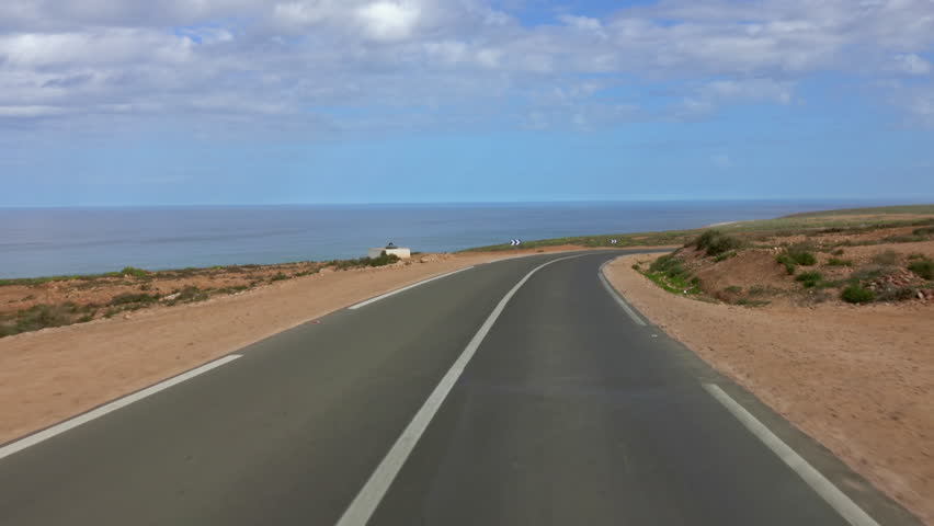 View from a car driving on the road along the Atlantic coast, Morocco, Africa, 4k