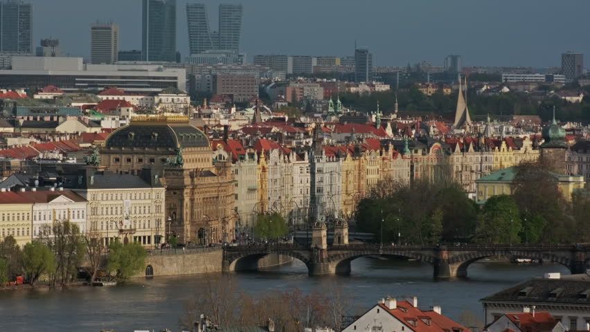 Old town of Prague at sunset, historic buildings, bridge and river Vltava. Praha city landscape, 4k