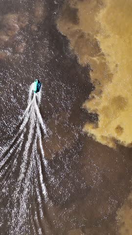 Boat sailing at Meeting of the Waters tourism landmark at Manaus Amazonas Brazil. Brown Amazon river side Black Negro River with two different colors. Amazon rainforest Brazil. Manaus Amazonas Brazi