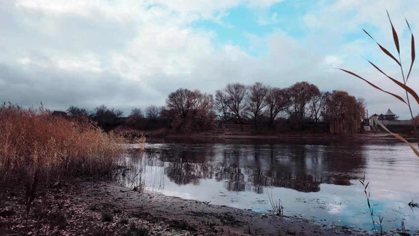 Beautiful autumn landscape with a lake and blue water. Landscape in cinematic colors. Sunset on the lake. 4K 60fps.
