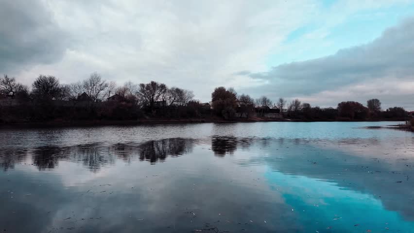 Beautiful autumn landscape with a lake and blue water. Landscape in cinematic colors. Sunset on the lake. 4K 60fps.
