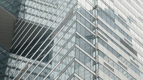 Close-up of a modern glass skyscraper facade with geometric zigzag lines, reflective windows, and steel structure, showcasing urban architecture and curtain wall design - Powered by Shutterstock - Get 15% off with code: PIKWIZARD15