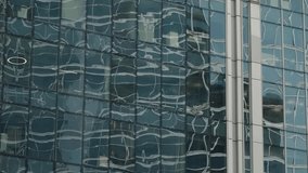 Abstract reflections ripple across the glass facade of a modern office skyscraper, revealing distorted patterns and a grid of windows that emphasize contemporary architecture - Powered by Shutterstock - Get 15% off with code: PIKWIZARD15