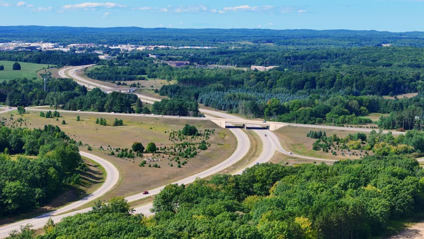 Aerial view showing highway US 131 passing through a forest landscape and rural area