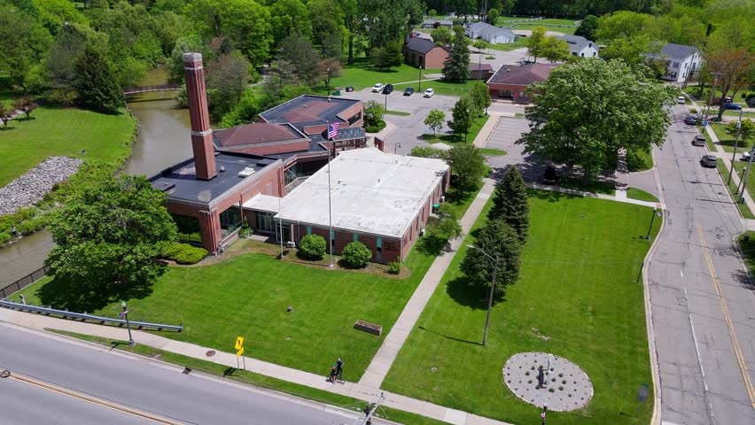 Milan Public Library building in Milan, Michigan, USA from aerial view. Public library facility and green spaces fostering community and knowledge in a small American town