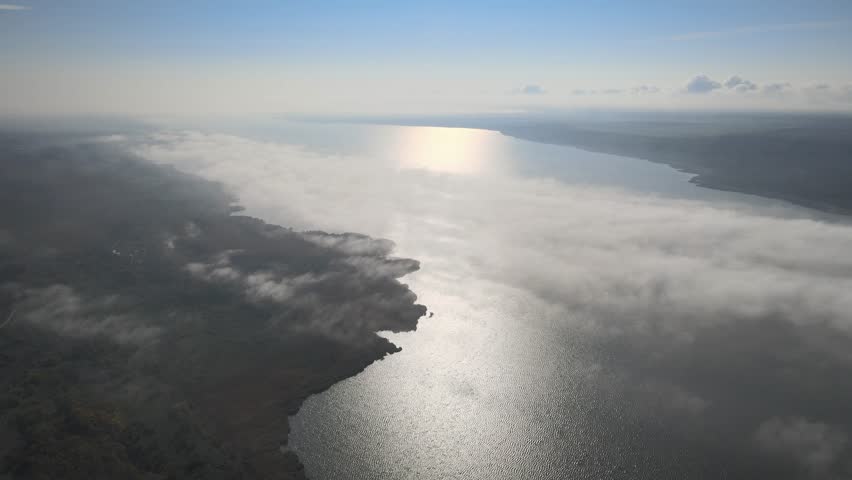Drone footage flying over lake above clouds in soft morning light

Cinematic drone footage flying over a lake in the early morning, above low clouds and fog. Soft natural light creates a calm, inspiring, and atmospheric scene. Ideal for nature, travel, meditation, wellness, and inspirational visual concepts