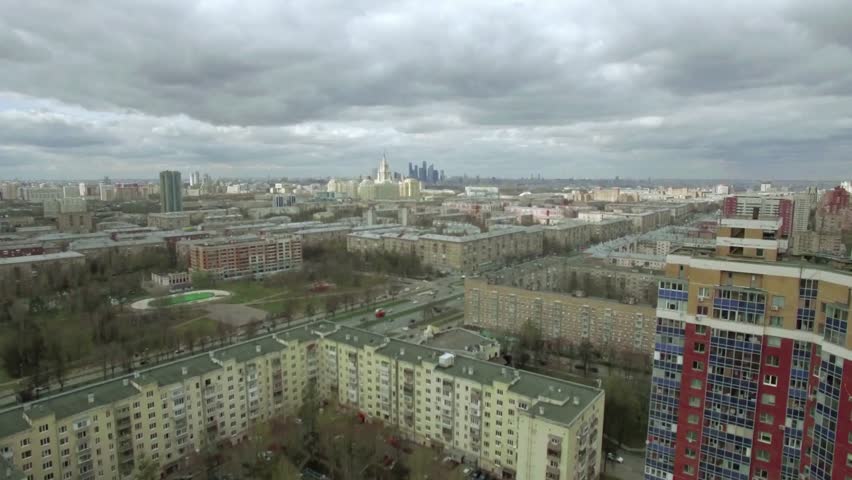 Aerial view of Moscow cityscape under a dramatic cloudy sky, Russia. High-angle drone perspective of the urban skyline, historic architecture, and modern buildings during an overcast day. Cinematic atmosphere in the Russian capital.