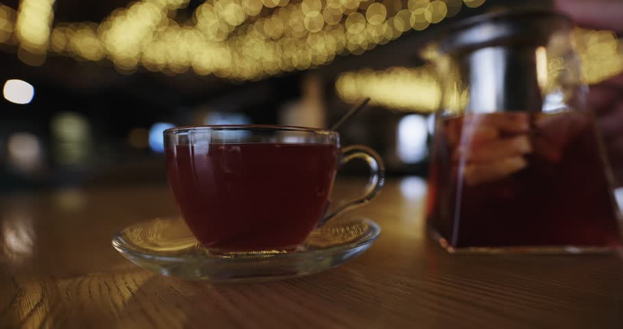 Pour raspberry tea into a cup in luxury restaurant, slow motion