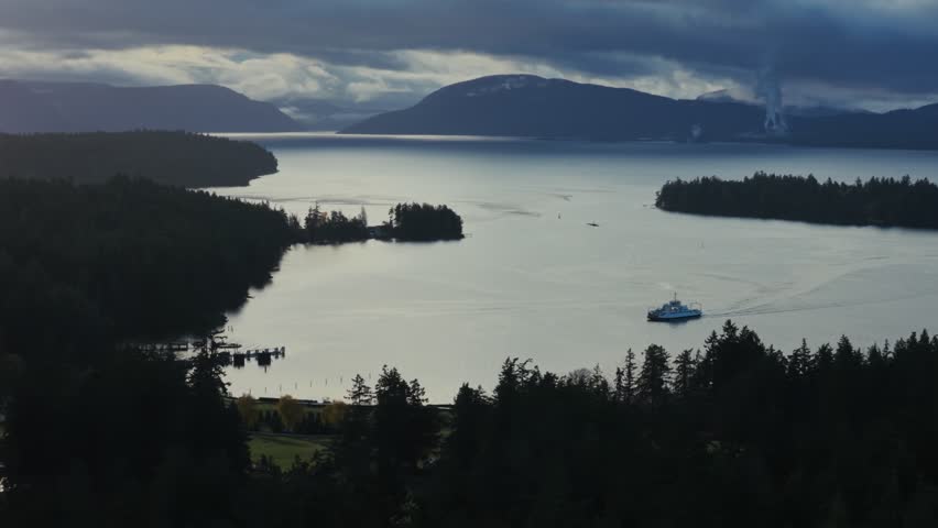 Ferry Crossing Calm Waters Near Thetis Island Under Overcast Sky. Vancouver, Canada. wide shot