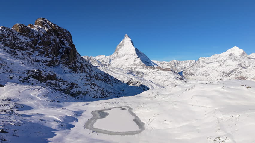 Frozen Riffelsee lake and Matterhorn mountain aerial view. Zermatt, Valais, Switzerland.