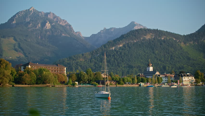 Scenic view of colorful boats on Wolfgangsee lake Austria surrounded by alpine mountains clear water and picturesque tourist city landscape in Europe