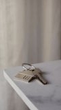 Close-up of hand holding house key with keychain , real estate success symbol - Powered by Shutterstock - Get 15% off with code: PIKWIZARD15