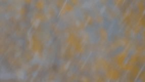 Snow falling, large and small snowflakes. Blurred tree branches with orange leaves in background. Snowy weather. Selective focus with bokeh effect. Abstract beginning of winter scene - Powered by Shutterstock - Get 15% off with code: PIKWIZARD15