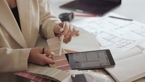 Architect reviews building plans and color schemes using digital tablet and swatches. - Powered by Shutterstock - Get 15% off with code: PIKWIZARD15